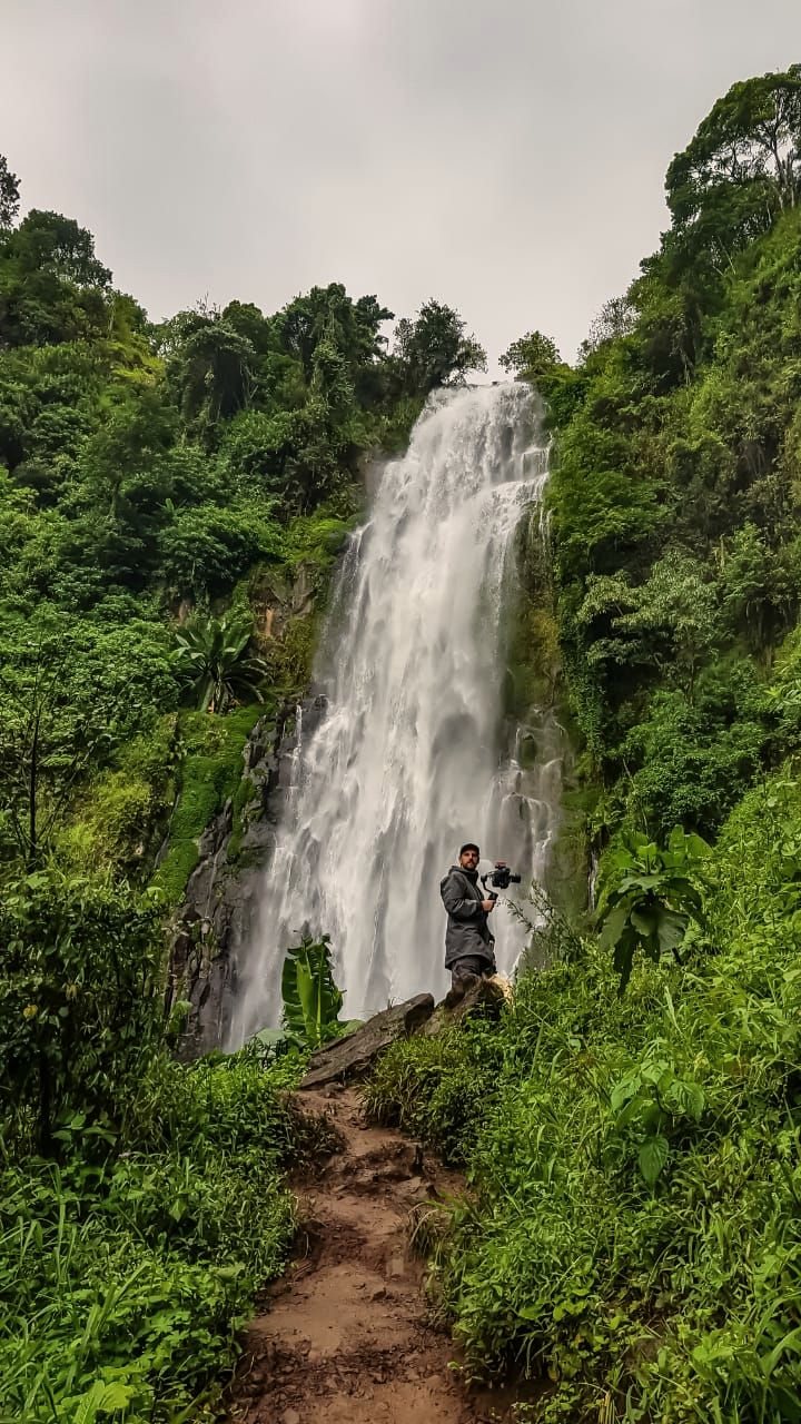A tall waterfall in the forest at the base of Kilimanjaro