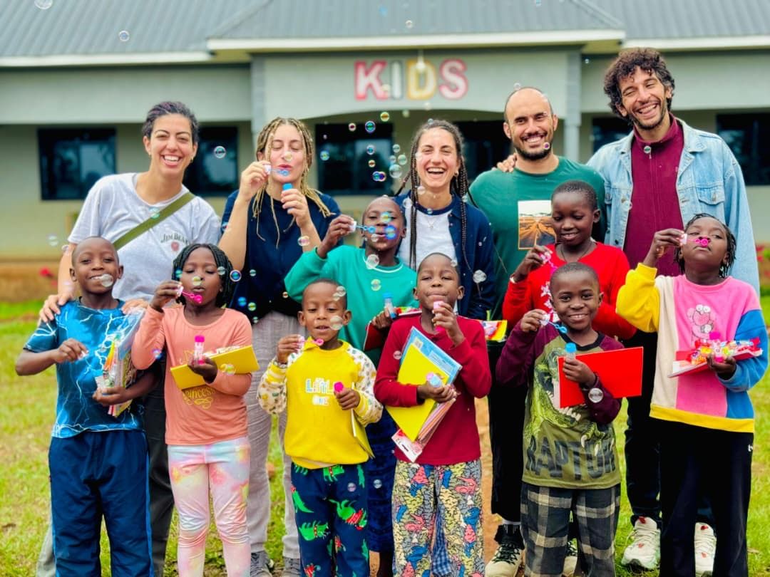 Visitors with a group of local children outside a school