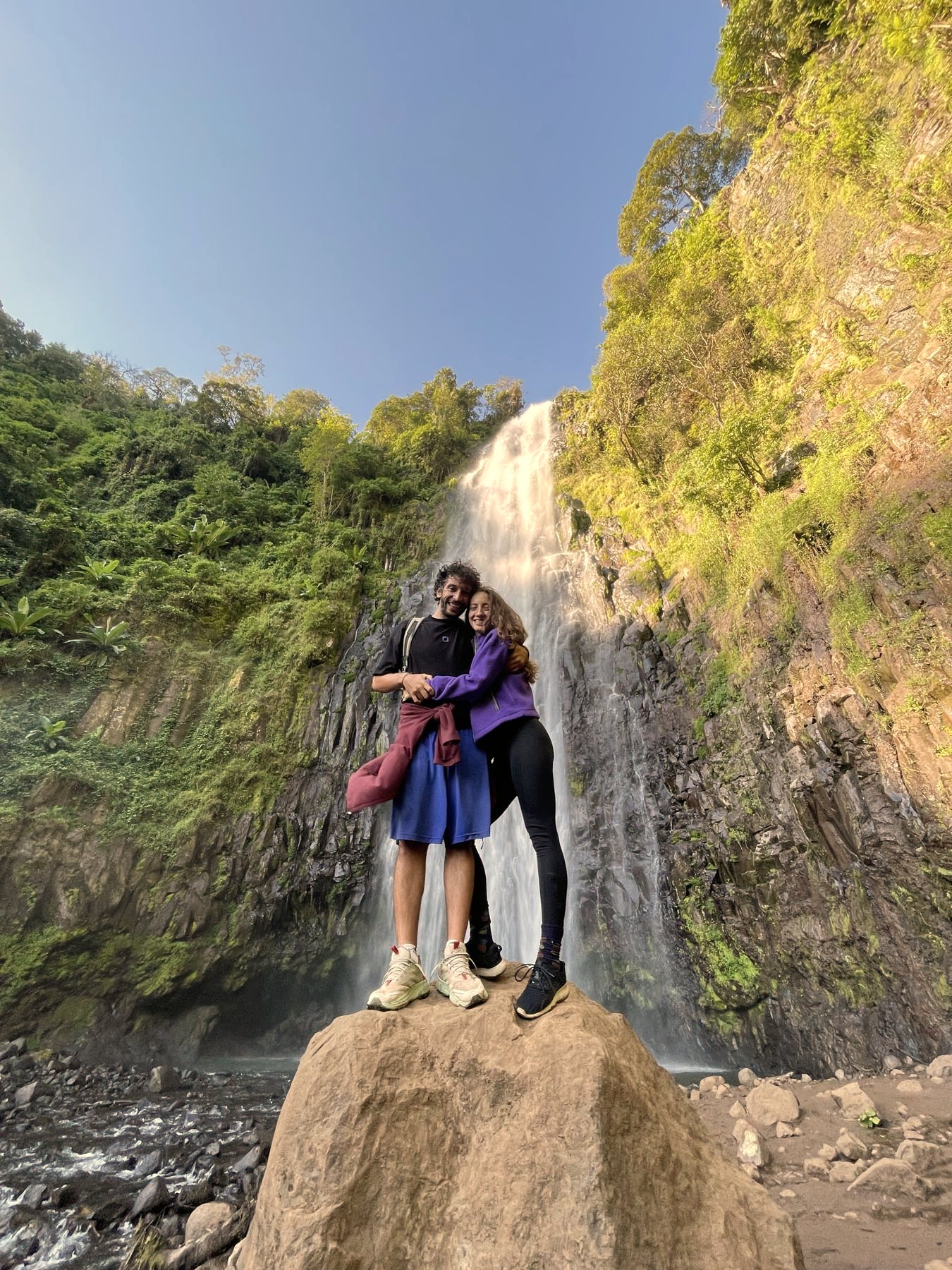Two guests at the foot of a waterfall near Uru East